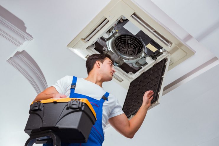 A Man Cleaning Commercial Air Conditioning Unit
